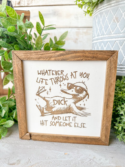 Whatever life throws that you duck and let it hit someone else. Laser Engraved Wood Sign.